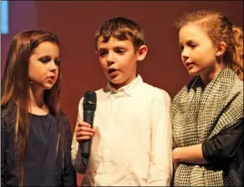  ??  ?? Taghmon Tops Group’s Megan Hogan, Harvey O’Brien and Ella Banville singing in an old Irish wake scene.