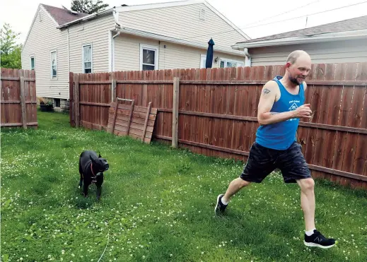  ??  ?? Christian Hainds plays with his dog Reyna in the backyard of his home in Hammond, Indiana. — All pictures/Ti Gong