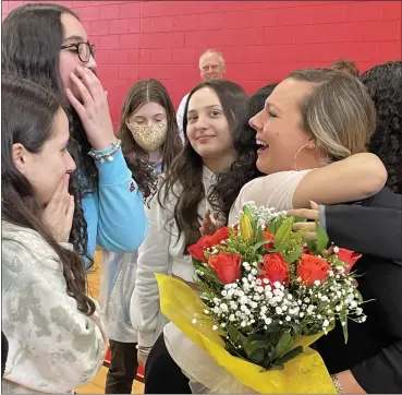  ?? PHOTO COURTESY OF UCS ?? Utica Community Schools Teacher of the Year Kelly Battle, far right, hugs her students after receiving her award at Davis Junior High School.