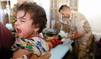  ??  ?? طفلة عراقية تبكي أثناء عالجها بعدما فرت مع أسرتها من الموصل أمس األول. (رويترز)