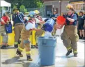  ??  ?? Junior firefighte­rs Ashely Kramer of Berwyn Fire Company and Riley Weaver of Lancaster County station 63 take part in the bucket brigade component of Chester County Department of Emergency Services’ Junior Public Safety Camp Olympics Thursday.