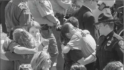  ?? Arkansas Democrat- Gazette/ BENJAMIN KRAIN ?? Mourners console one another Monday at the Russellvil­le funeral of Yell County sheriff’s Lt. Kevin Mainhart, 46.