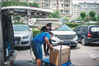  ?? PROVIDED TO CHINA DAILY ?? Wu Honghuang (rear), a clerk from a gaming company in Beijing, moves in to his new home shared with a friend outside the Fifth Ring Road in the northeast of the city.