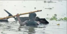  ?? HT ?? A child wades through the flood waters in a low lying area of Prayagraj.