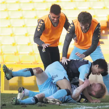  ??  ?? KEY MOMENT: Cambridge United celebrate Liam O’neil’s late winner at Port Vale on Saturday.