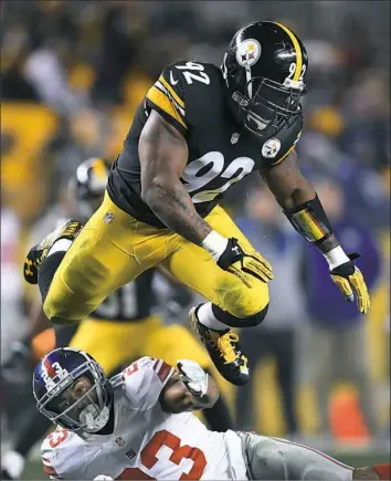  ?? Peter Diana/Post-Gazette ?? Linebacker James Harrison leaps over New York Giants running back Rashard Jennings Sunday at Heinz Field.