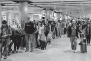  ?? Carl Court/Tribune News Service ?? Crowds of travelers wait to pass through the security check at Heathrow Airport in London.