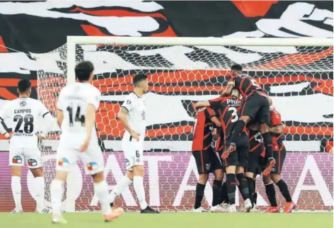  ??  ?? Los jugadores de Paranaense celebran uno de sus goles ante la resignada mirada de los colocolino­s.