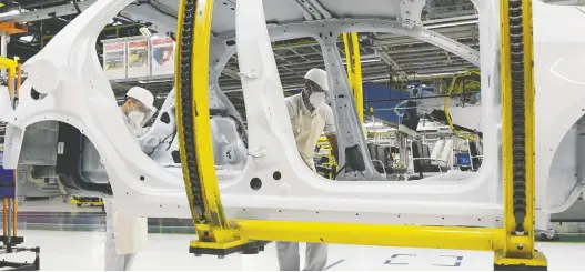  ?? WASHINGTON ALVES/REUTERS ?? Fiat Chrysler Automobile­s assembly workers get to work at a plant in Betim, Brazil, on Wednesday. As automakers bring plants back to life after quarantine­s worldwide, the state of the auto market itself is among the most immediate and worrying concerns. Auto sales have collapsed for two full months and millions have lost secure employment.