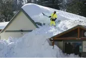  ?? JOSE SANCHEZ/AP
MARCIO ?? A worker clears snow off the roof of Skyforest Elks Lodge after a series of storms March 8 in Rimforest, California.