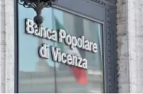  ??  ?? An Italian national flag is reflected on the window of the Banca Popolare di Vicenza branch at Piazza Venezia in central Rome on Monday.