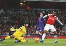  ?? AFP ?? Arsenal Striker Alexandre Lacazette (right) vies with Liverpool goalkeeper Alisson Becker during their clash at Emirates Stadium on Saturday. The match ended in a 1-1 draw.