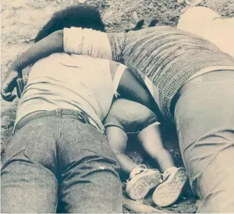  ?? AP FILES ?? A man and woman lie face down with a child between them in Jonestown, Guyana, two days after the massacre in 1978. At that point, at least 775 of the more than 900 bodies had been found.