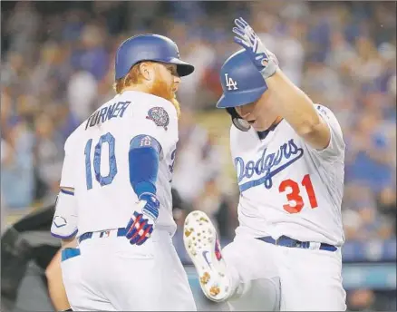  ?? Victor Decolongon Getty Images ?? DODGERS LEFT FIELDER Joc Pederson, right, is greeted at the plate by third baseman Justin Turner after hitting a solo home run in the first inning. Pederson hit a two-run home run in the fourth inning and a double in the third. Turner had two hits.