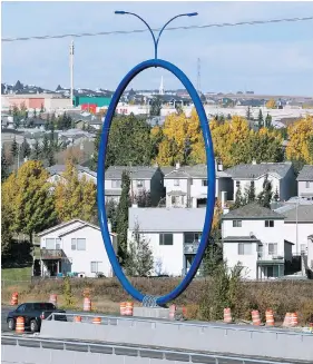  ?? AL CHAREST / POSTMEDIA NEWS / QMI AGENCY ?? Travelling Light, a $500,000 blue hoop that sits on a road near the airport, is a striking piece of public art that has sparked confusion from Calgarians, Jen Gerson writes.