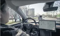  ?? QILAI SHEN/BLOOMBERG ?? A sales assistant drives a Tesla Inc. Model Y electric vehicle in Shanghai, China, earlier this year. Consumer Reports engineers in Texas claim they fooled a Model Y vehicle to drive via its autopilot feature without anyone in the driver’s seat.