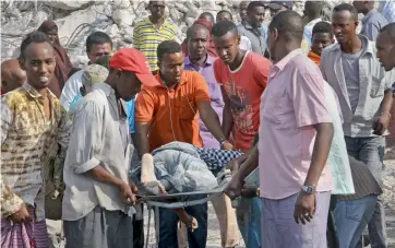  ?? AP ?? Somalis remove the body of a man killed in Saturday’s blast, in Mogadishu, Somalia on Sunday.—