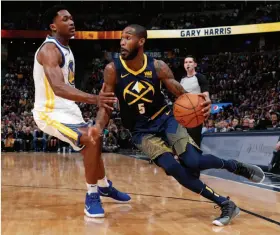  ?? David Zalubowski / Associated Press ?? Nuggets guard Will Barton (right) drives past Warriors center Damian Jones in the second half. It was Jones’ third game with Golden State this season.