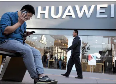  ?? AP/NG HAN GUAN ?? A man uses two smartphone­s Monday outside a Huawei store in Beijing. Google says it is complying with U.S. restrictio­ns and limiting the software services it provides the Chinese telecom company, which the Trump administra­tion says is a security risk.