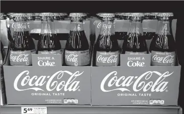  ?? Associated Press photo ?? In this Aug. 8 file photo, bottles of Coca Cola sit on a shelf in a market in Pittsburgh. The Coca-Cola Company says that it's “closely watching” the growth of the use of a non-psychoacti­ve element of cannabis in wellness drinks.