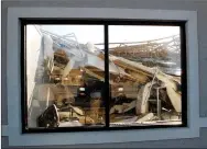  ?? Marc Hayot/Herald-Leader ?? A view through the window of the Eastgate Shopping Center shows the missing roof and damage to the inside of the building resulting from the storm in the early hours of Monday morning.