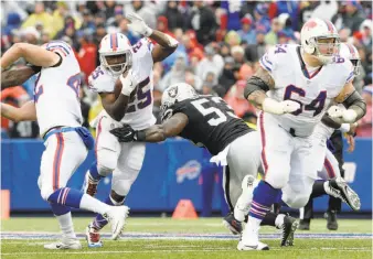  ?? Adrian Kraus / Associated Press ?? Buffalo running back LeSean McCoy tries to avoid a hit by Raiders linebacker NaVorro Bowman. McCoy rushed for 151 yards, including 48 on a fourth-quarter touchdown.