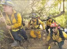  ?? Genaro Molina Los Angeles Times ?? MEMBERS of the Los Angeles Fire Department’s Crew 3 climb a hill in Bel-Air to do mop-up work on the Skirball fire on Thursday.