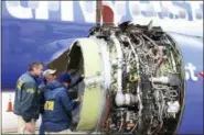  ?? NTSB VIA AP ?? National Transporta­tion Safety Board investigat­ors examine damage to the engine of the Southwest Airlines plane that made an emergency landing at Philadelph­ia Internatio­nal Airport in Philadelph­ia on Tuesday. The Southwest Airlines jet blew the engine...