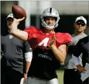  ?? AP ERIC RISBERG ?? PHOTO BY Oakland Raiders quarterbac­k Derek Carr throws as head coach Jon Gruden, right, looks on during NFL football training camp Monday, July 29, in Napa, Calif.