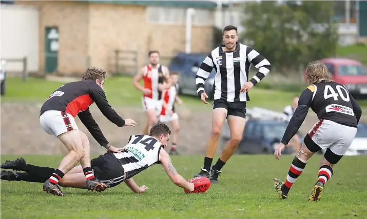  ?? Photograph­s: Jeff Tull ?? Poowong’s Michael Robertson scrambles for the ball as his Nyora opponent attempts a tackle.