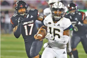 ?? AP PHOTO/TIMOTHY D. EASLEY ?? Georgia Tech quarterbac­k TaQuon Marshall outruns Louisville linebacker Dorian Etheridge (17) during the first half of last Friday’s game at Louisville. Marshall has led the Yellow Jackets to two straight lopsided wins after a 1-3 start.