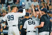  ?? FRANK FRANKLIN II/ASSOCIATED PRESS ?? New York Yankees’ Aaron Judge, left, celebrates with teammates after hitting a home run against the Kansas City Royals during the ninth inning of Thursday’s game in New York.