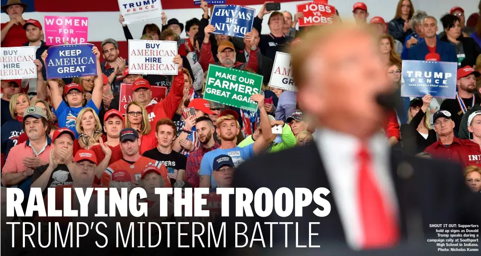  ??  ?? SHOUT IT OUT: Supporters hold up signs as Donald Trump speaks during a campaign rally at Southport High School in Indiana. Photo: Nicholas Kamm