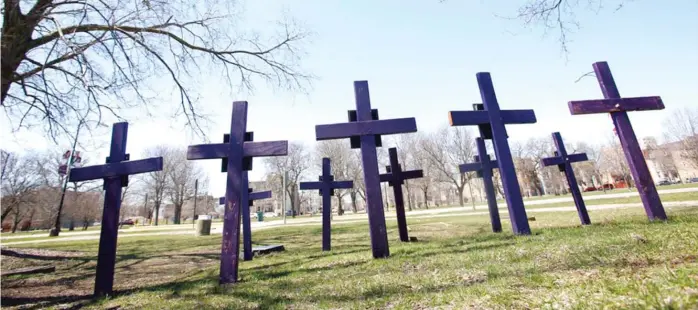  ?? MARTHA IRVINE/AP ?? Crosses representi­ng victims of gun violence stand outside Collins Academy High School in Chicago’s North Lawndale neighborho­od this spring.