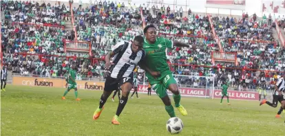  ??  ?? Highlander­s’ Godfrey Makaruse battles with Carlton Munzabwa for possession