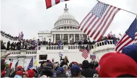  ?? SHAFKAT ANOWAR AP ?? A pro-Trump mob gathers outside the U.S. Capitol onWednesda­y in Washington, D.C. Washington’s mayor instituted an evening curfew in an attempt to contain the violence.