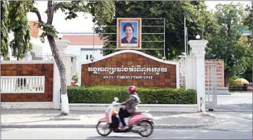  ?? PHA LINA ?? A motorbike passes in front of the Anti-Corruption Unit headquarte­rs in Phnom Penh.