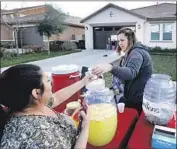  ?? Allen J. Schaben Los Angeles Times ?? SALYNN SIMON, right, handing hot chocolate to Wendy Martinez, hosts a lemonade stand that raised $2,000 that will go to a fund for the Turpin children.