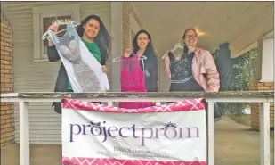  ?? Special to The Saline Courier ?? Young Adult Librarian Jennifer Watson, right, and Children’s Library Manager Sarabeth Lesko show some of the library’s prom dresses with Project Prom Director Bekka Wilkerson.