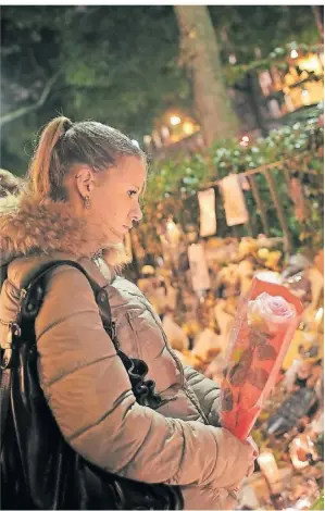  ?? FOTO: CHRISTOPHE ENA/AP ?? Eine Frau gedenkt nach dem Terrorakt im November 2015 der Opfer. Viele hatten vor der Bataclan-konzerthal­le Blumen nierdergel­egt.