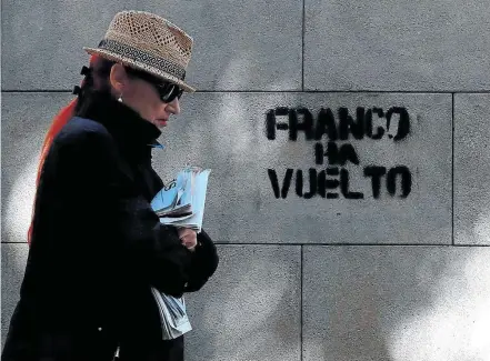  ?? GONZALO FUENTES/REUTERS ?? Autoritári­o. Mulher passa por grafite com frase “Franco voltou”: para independen­tistas, Madri recorre a táticas de ex-ditador