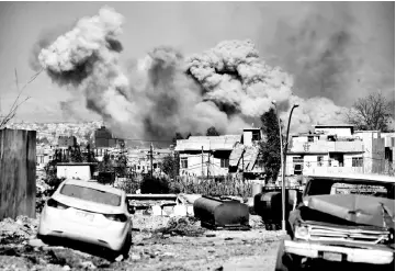  ?? — AFP photo ?? Smoke plumes rise after an airstrike in west Mosul as Iraqi forces advance in the city during the ongoing battle to seize it from the jihadists of the Islamic State (IS) group.