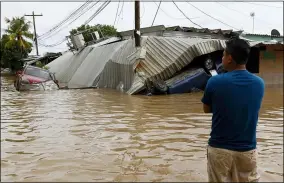  ?? THE ASSOCIATED PRESS ?? A resident looks at damage caused by Hurricane Eta in a neighborho­od of Planeta, Honduras, Nov. 6. As the remnants of Hurricane Eta moved back over Caribbean waters, government­s in Central America worked to tally the displaced and dead, and recover bodies from landslides and flooding that claimed dozens of lives from Guatemala to Panama.