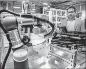  ?? ZBIGNIEW BZDAK/CHICAGO TRIBUNE ?? Brian Pelke, president of Kay Manufactur­ing, looks at the automotive parts company’s newest Universal Robot.