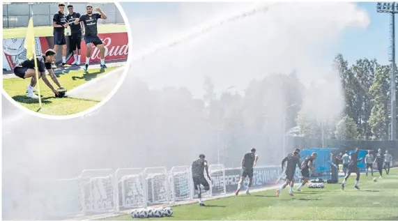  ??  ?? Fun and games: Raheem Sterling turns a sprinkler around to shower his team-mates during an England training session near Repino yesterday