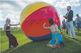  ?? Seth McConnell, Special to The Denver Post ?? Raissa Fernandez signs a giant beach ball before the Phish concert at Dick’s Sporting Goods Park on Sept. 1 in Commerce City.