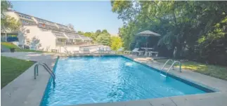  ??  ?? A canopy of trees surrounds the swimming pool at Waterchase Condominiu­ms.