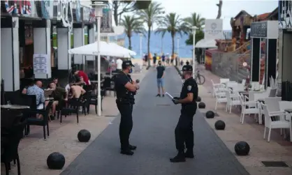  ?? Photograph: Joan Mateu/AP ?? Police officers patrol at the resort of Magaluf on the island of Mallorca earlier this month. Bars on the island were forced to close after reports of partying by young German tourists.