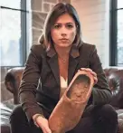  ?? MARK SUPIK/PROVIDED ?? CNN entertainm­ent reporter Chloe Melas holds one of the wooden shoes that her grandfathe­r, Frank Murphy, wore during a forced march from a prisoner of war camp in January 1945.