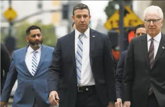  ?? Gregory Bull / Associated Press ?? ExRep. Duncan Hunter of California ( center) was set to begin his prison sentence